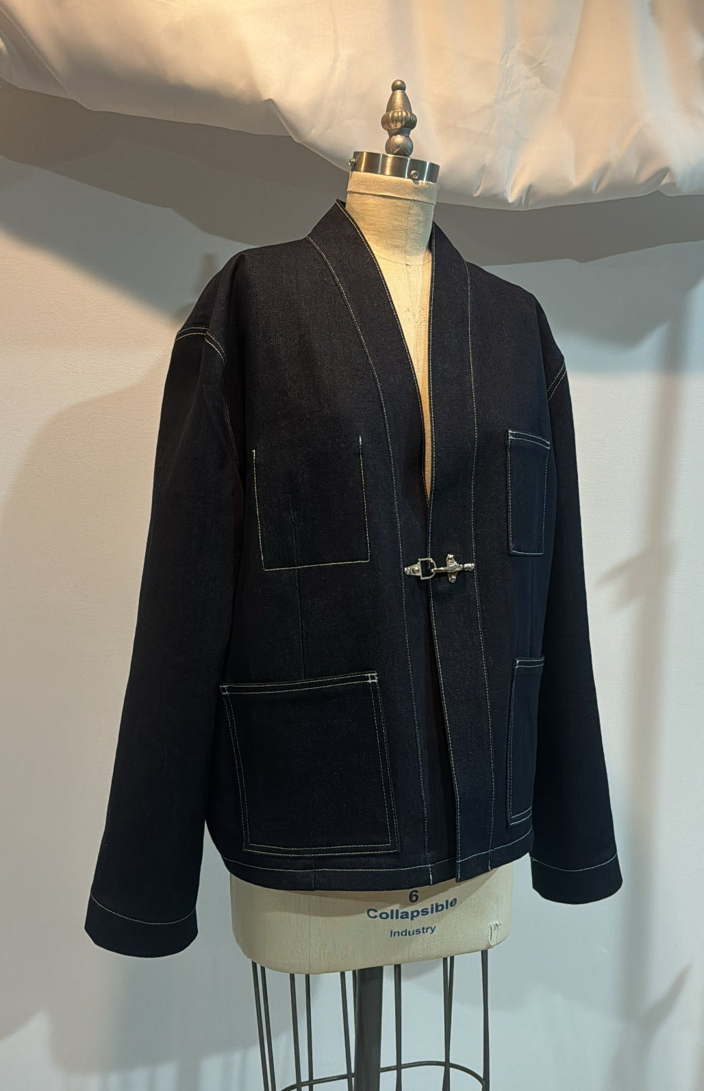 Dark jacket on a mannequin against a white background