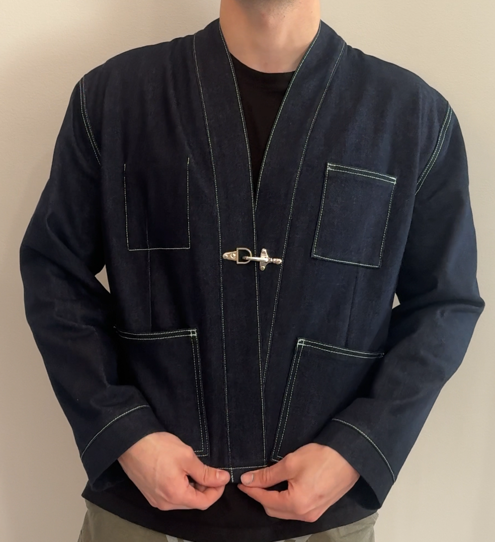 Man wearing a dark blue jacket with a zipper against a plain background