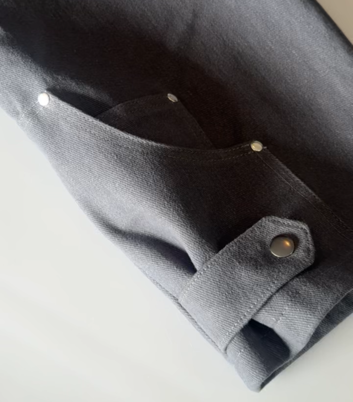 Close-up of a gray fabric with a button on a light background