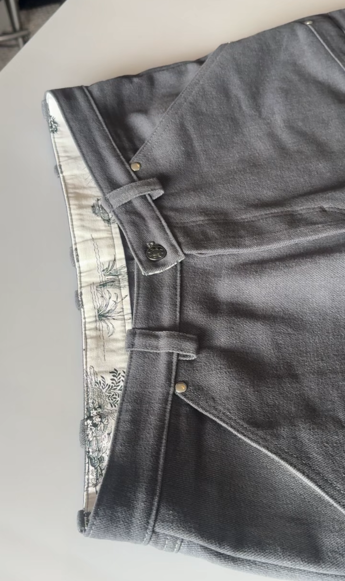 Close-up of a pair of gray jeans on a light background